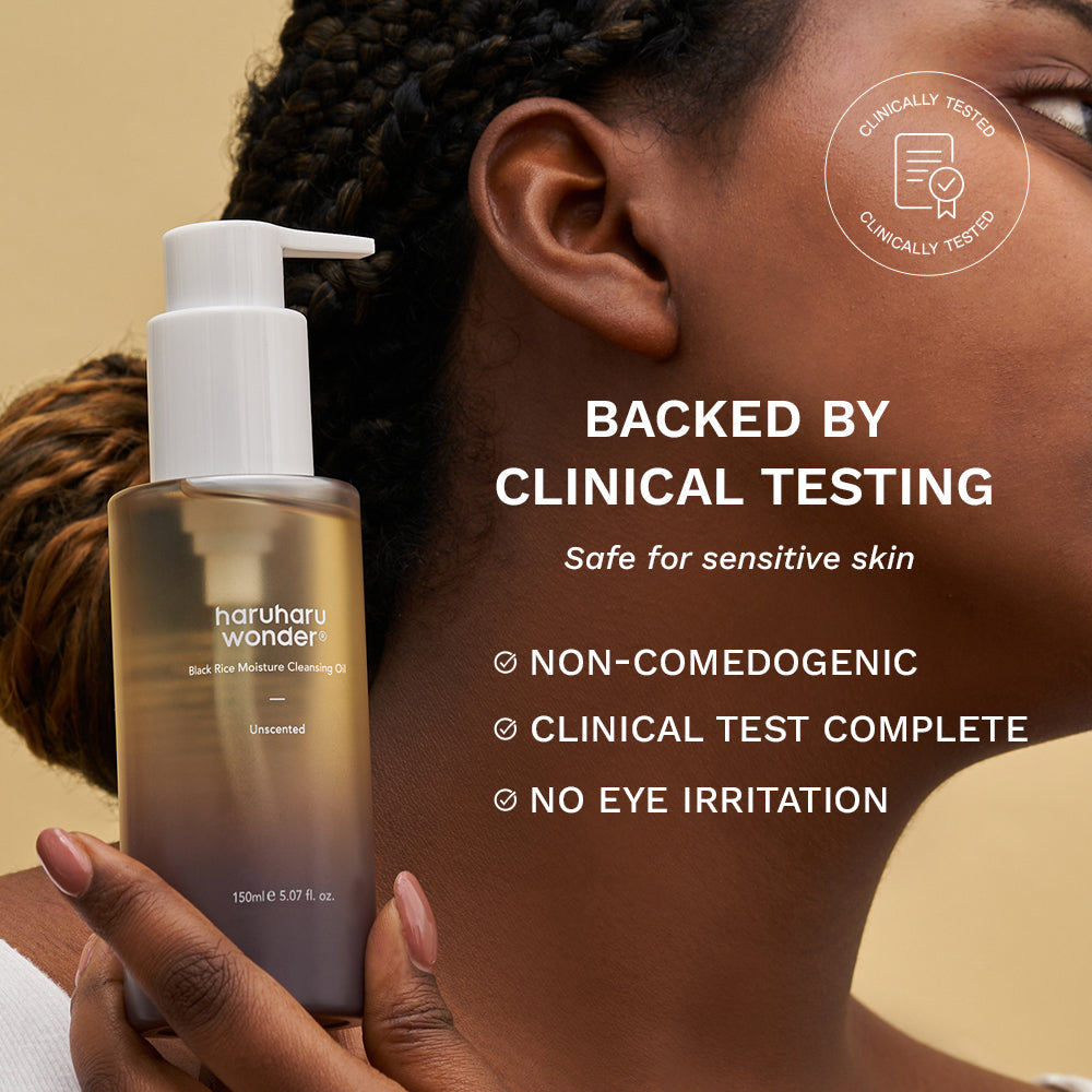 Haruharu Wonder Black Rice Deep Cleansing Oil - 150ml — model holding the 150 ml pump bottle beside her shoulder with manufacturer test labels.