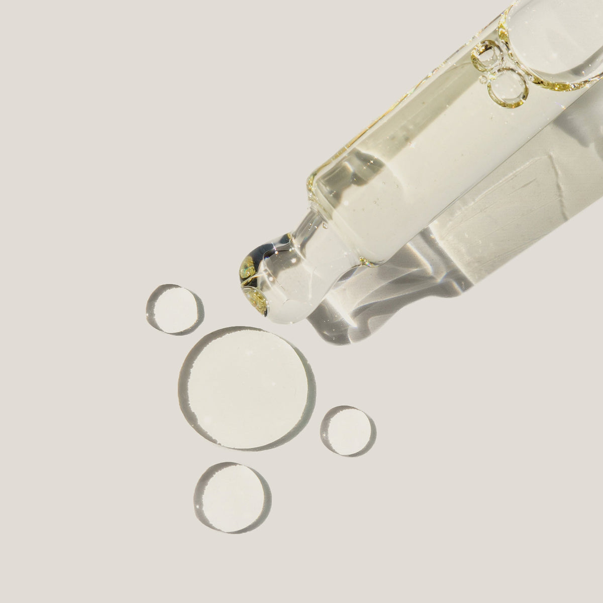 Haruharu Wonder Black Rice Facial Oil - 30ml — close-up of clear oil droplets beside the open bottle and dropper.