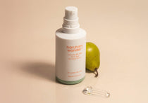 Haruharu Wonder Centella 4% TXA Gel Serum - 30ml — uncapped 30 ml TXA serum bottle with a pear and clear gel texture on a peach-coloured surface.