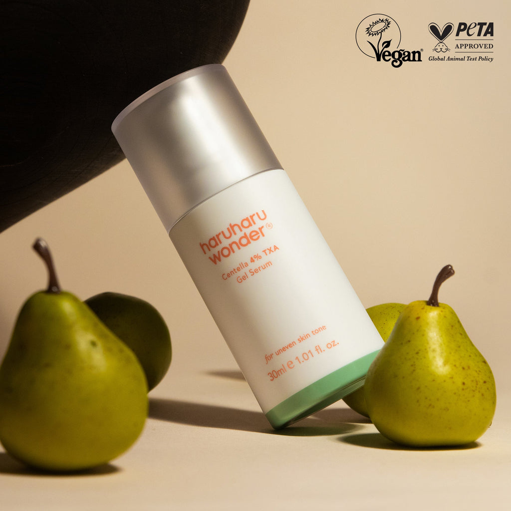 Haruharu Wonder Centella 4% TXA Gel Serum - 30ml — 30 ml TXA gel-serum bottle leaning between pears in warm light.