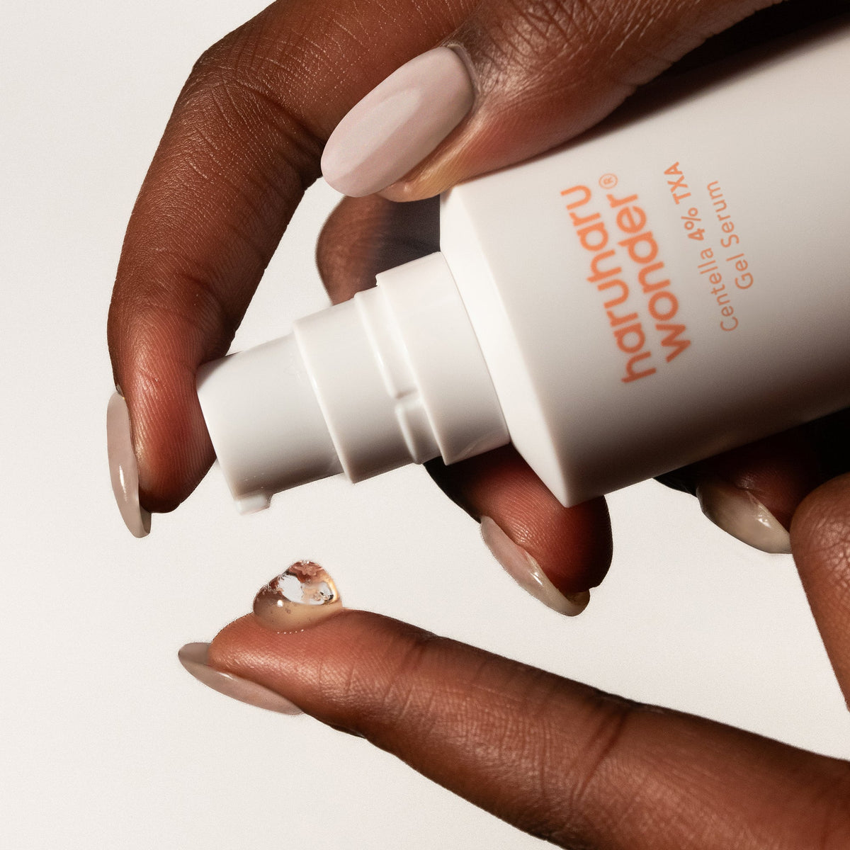 Haruharu Wonder Centella 4% TXA Gel Serum pump dispensing a clear gel drop onto a fingertip.