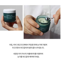 Heimish Marine Care Eye Cream 30 ml — a hand holding the closed jar and a second view scooping cream with the supplied metal applicator, with original use guidance.