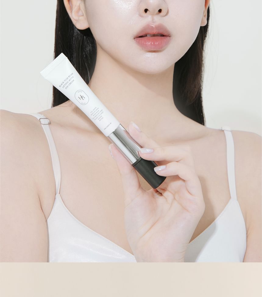 Heveblue Black Yuja Bean Lifting Auto Eye Cream 15 ml — model holding the eye-cream applicator.