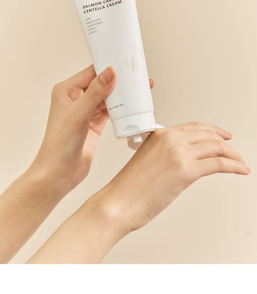 Heveblue Salmon Caring Centella Cream 100 ml — cream tube held over the hand.