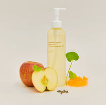 Heveblue Salmon Caring Centella Light Cleansing Oil - 250ml — bottle beside apple and centella.