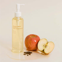 Heveblue Salmon Caring Centella Light Cleansing Oil 250 ml, shown beside whole and sliced apples and apple seeds.