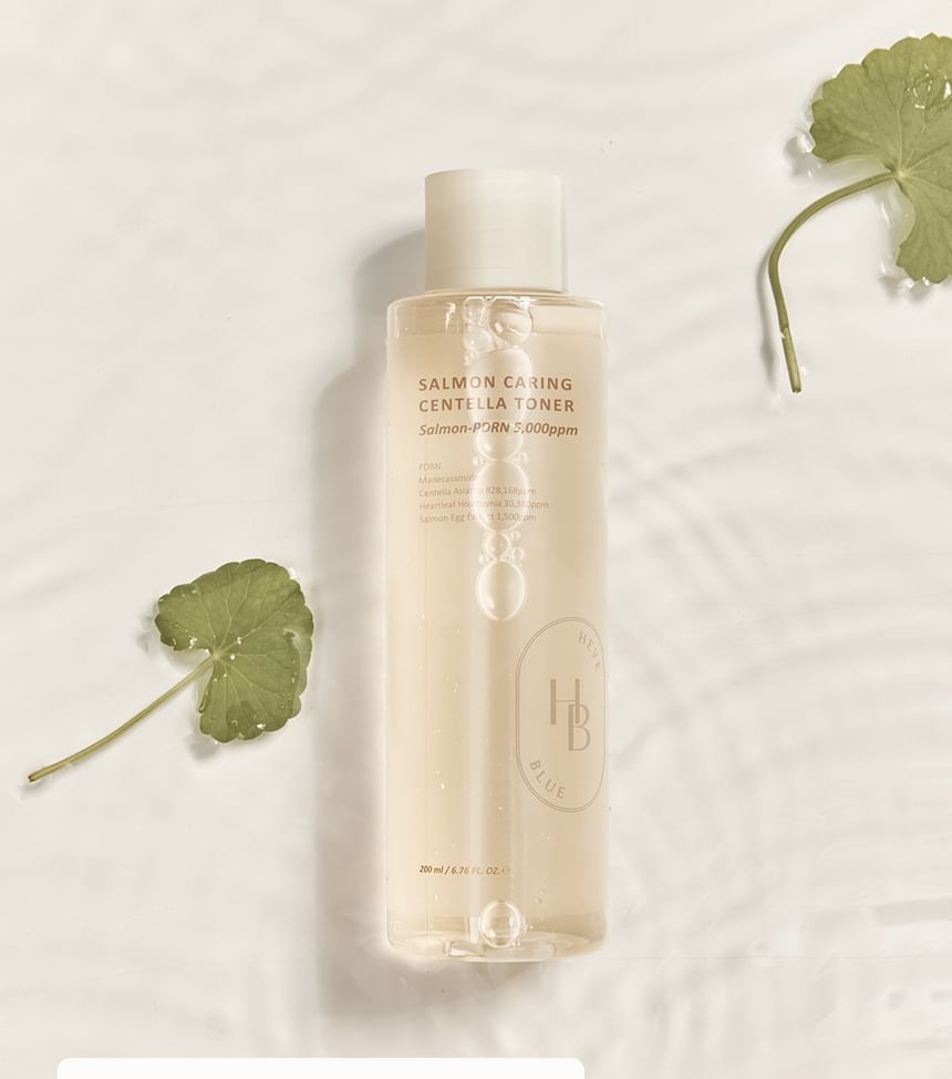 Heveblue Salmon Caring Centella Toner 200 ml — toner bottle and centella leaves.