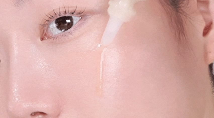 Heveblue Salmon Caring Newpair PDRN Booster 100,000 Shot Essence 5 ml — essence applied to the cheek.